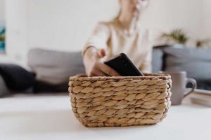 Minimalismo digital. Mujer deja el teléfono en una cesta