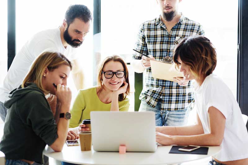 Compañeros de trabajo alrededor de un ordenador