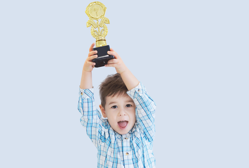 Niño levantando un trofeo