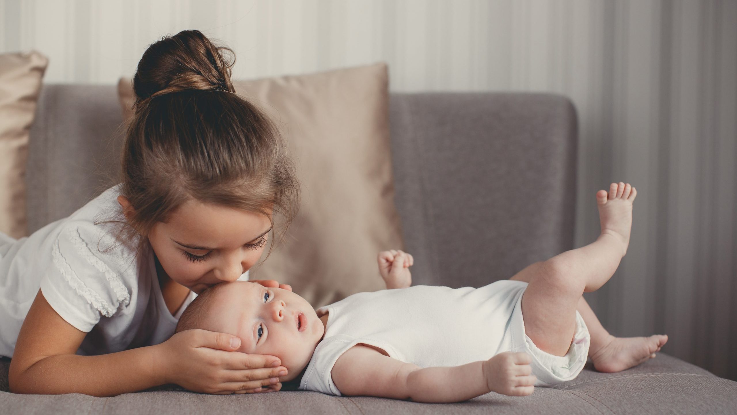 Little girl with a newborn baby brother